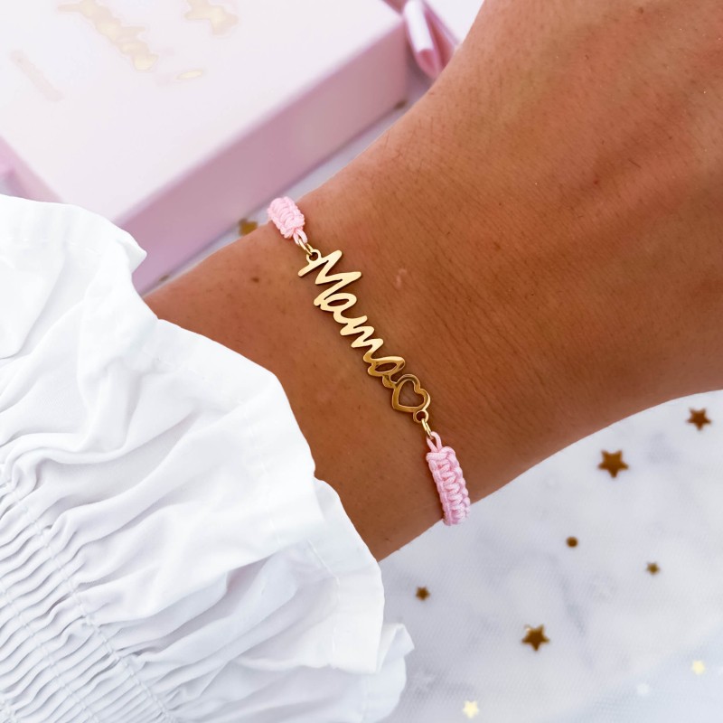 Różowa bransoletka z metalowym napisem MAMA i serduszkiem na kobiecej dłoni - elegancka personalizowana biżuteria
