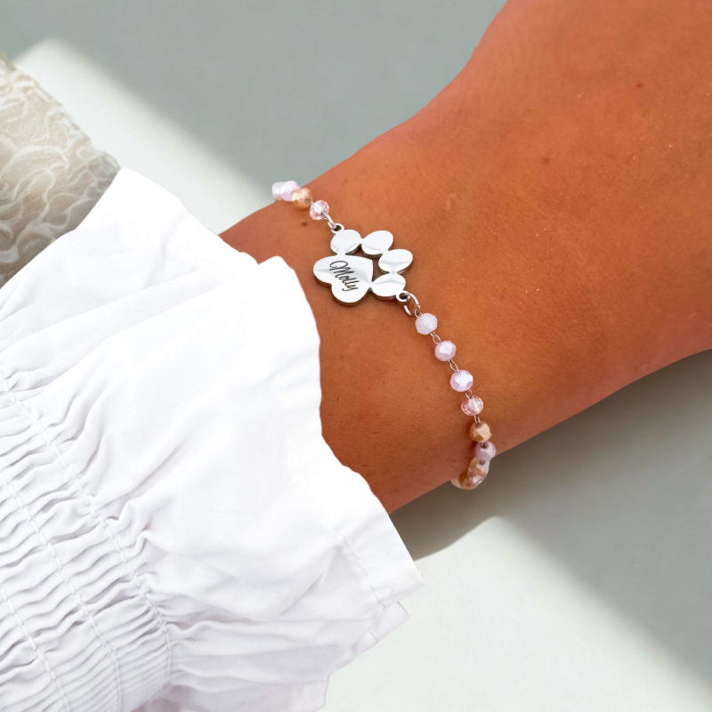 Personalizowana bransoletka z grawerem imienia na zawieszce w kształcie łapki, stal srebrna i koraliki. Prezent dla posiadaczy zwierząt