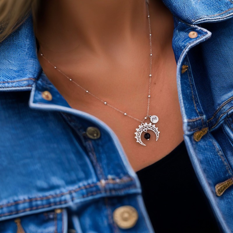 Srebrny naszyjnik z zawieszką w kształcie półksiężyca i czarnym turmalinem na kobiecie. Stylowa biżuteria ze stali chirurgicznej – idealny dodatek do codziennych i wieczorowych stylizacji.