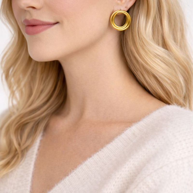 Złote kolczyki koła na modelce prezentujące elegancki wygląd biżuterii na uchu. Klasyczna forma pasuje do codziennych oraz eleganckich stylizacji.