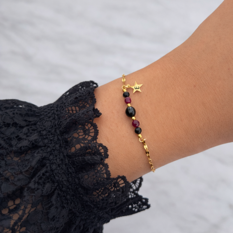 Złota bransoletka damska ze stali chirurgicznej z czarnymi i bordowymi kamieniami na nadgarstku